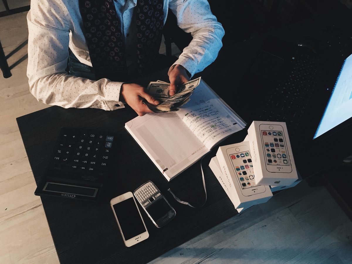 Ondernemer sorteert administratie en contant geld op een bureau